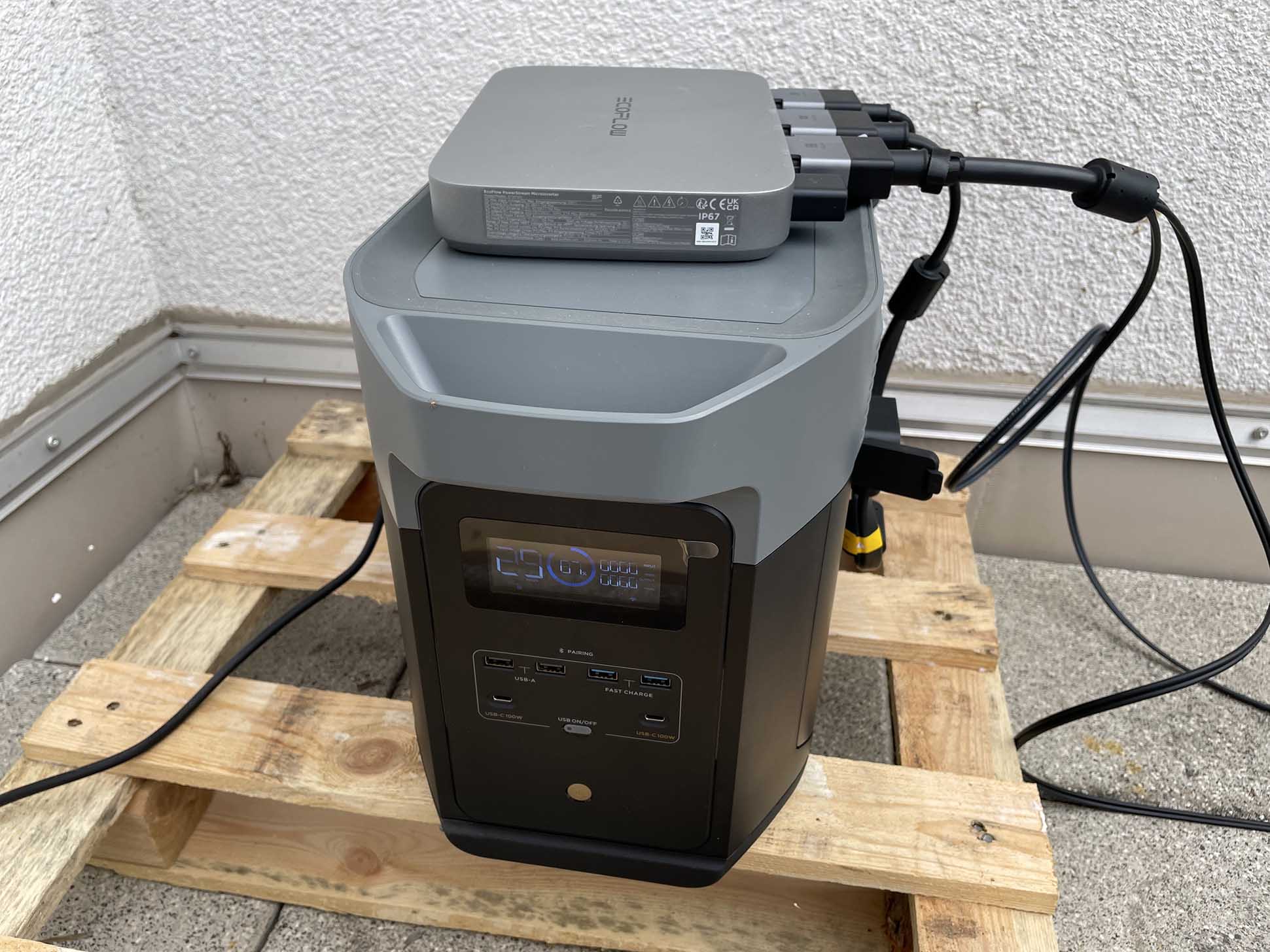 Der EcoFlow DELTA 2 Max Solargenerator und  Notstromaggregat steht auf einer Palette und der EcoFlow Powerstream Wechselrichter liegt drauf.